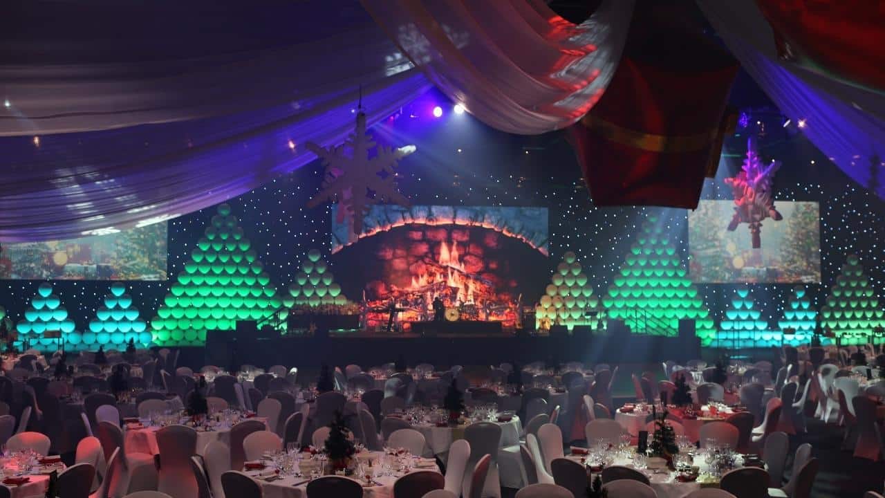 Large Christmas event theme with illuminated Christmas tree backdrop.