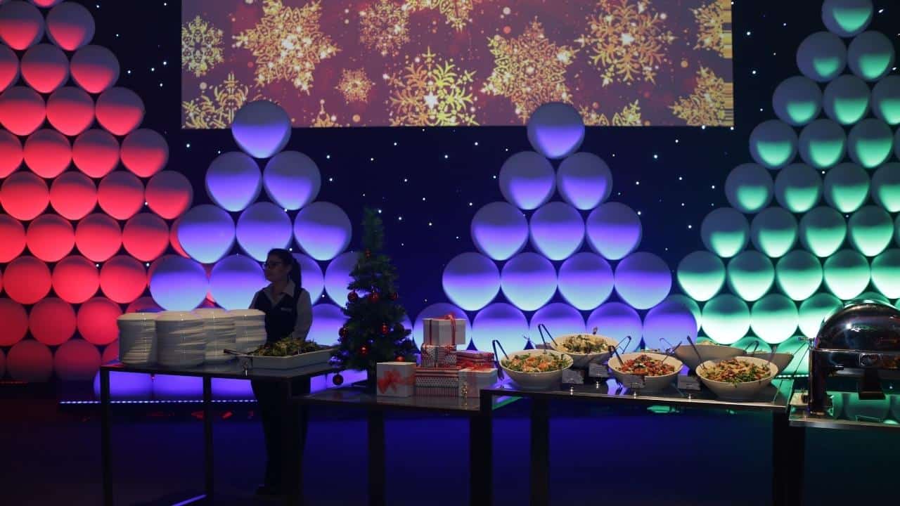 Christmas trees made out of Orb Wall panels as backdrop with Christmas party catering on the table in front.